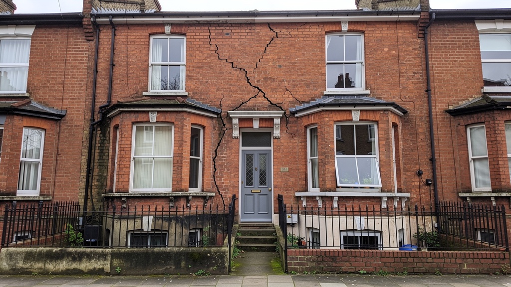 Victorian terraced house in South London showing structural cracks and building defects visible on the exterior brickwork